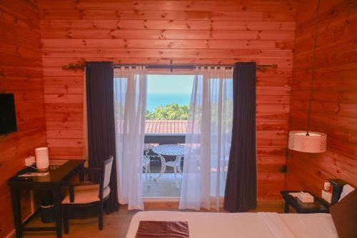 Habitación con cama, mesa y ventana en The Regalia Resort, en Mandrem