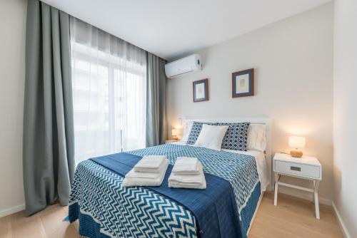 ポルトにあるGuestReady - Gemini Apartmentのベッドルーム(青と白のベッド1台、窓付)