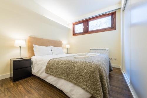 1 dormitorio con 1 cama grande y ventana en GuestReady - Flat59 Terrace, en Oporto