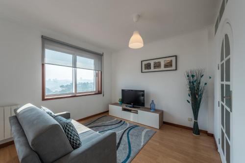 a living room with a couch and a television at GuestReady - Porto Magic View in Vila Nova de Gaia