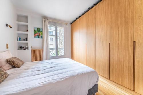 Un dormitorio con una cama grande y una ventana en appartement cosy proche Paris en Saint-Mandé