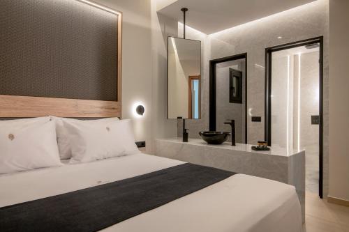 a bedroom with a large white bed and a bathroom at Anantia Villa 1 - Scenic View, Luxury Experience in Episkopi (Heraklion)