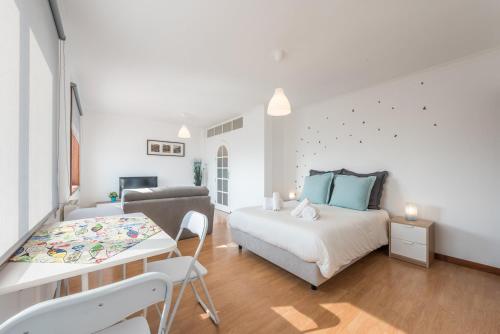 a white bedroom with a bed and a couch at GuestReady - Porto Magic View in Vila Nova de Gaia