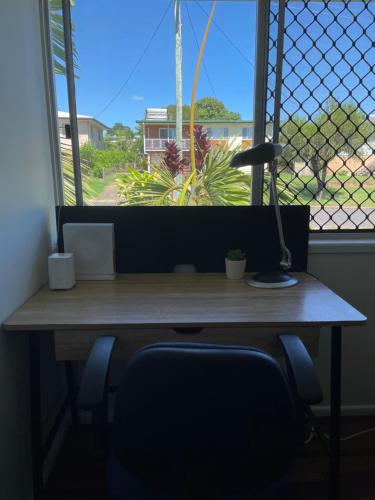 una scrivania con lampada di fronte a una finestra di Venables a Rockhampton