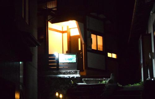 a door to a building at night with a television at Komorebi/こもれび in Takayama