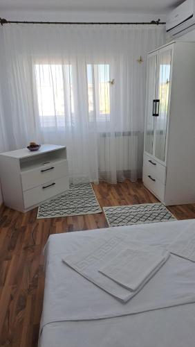 a bedroom with a bed and a dresser and a mirror at Apartament Nicol in Drobeta-Turnu Severin