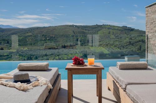 two beds and a table with a glass of orange juice at Anantia Villa 1 - Scenic View, Luxury Experience in Episkopi (Heraklion)
