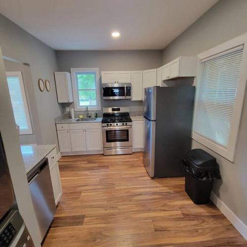 a kitchen with stainless steel appliances and wooden floors at Walk to Niagara Falls. Renovated 3 bed house! in Niagara Falls