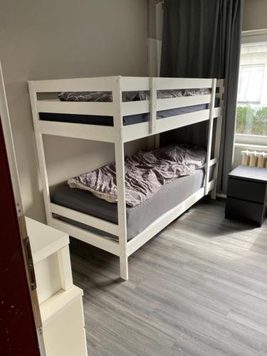 2 weiße Etagenbetten in einem Zimmer in der Unterkunft M&R Hostel in Rostock