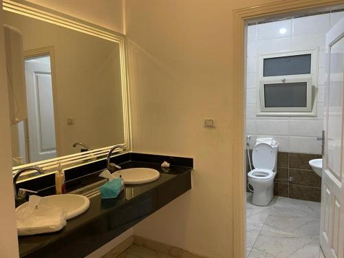 łazienka z 2 umywalkami i toaletą w obiekcie فيلا العائلة w mieście ‘Ezbet Sharikât Wardan