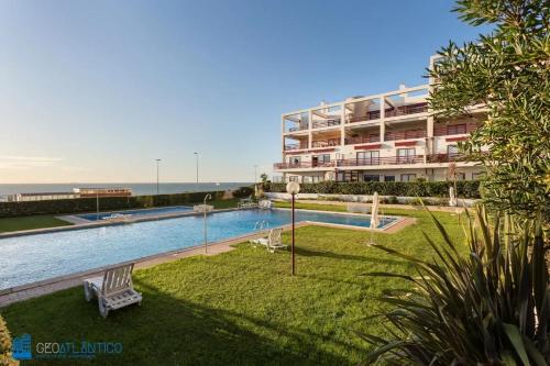 a swimming pool in front of a large building at Gaia Beach & Pool Residence - Porto South Seashore in Vila Nova de Gaia