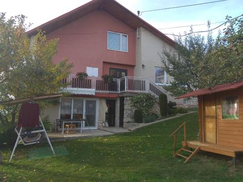 a house with a balcony and a yard at Ubytovanie Poráč in Poráč