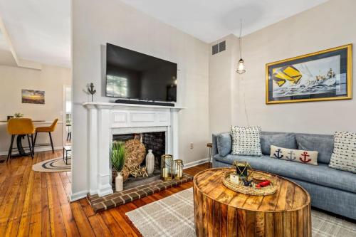 a living room with a blue couch and a fireplace at Fisher House - Downtown Annapolis! in Annapolis