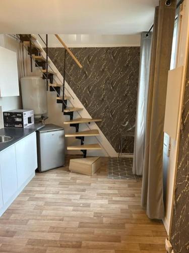 eine Küche mit einer Treppe in einem Zimmer in der Unterkunft Duplex Huper in Amiens