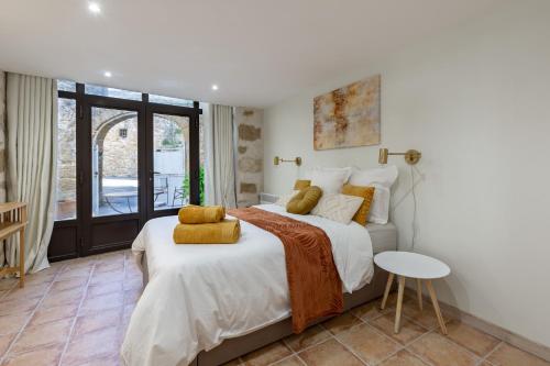 ein Schlafzimmer mit einem großen Bett und einem Tisch in der Unterkunft La Parenthèse, chambres d'hôtes in Rochegude