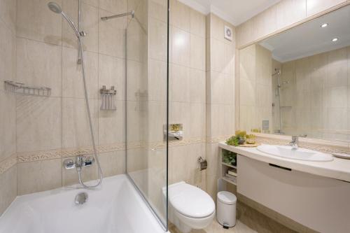 een badkamer met een bad, een toilet en een wastafel bij Mare Vista Suite in Varna