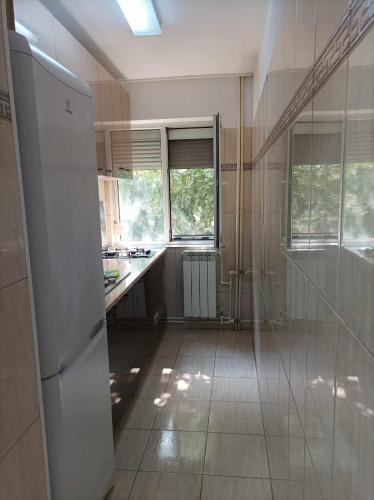 a kitchen with a white refrigerator and a window at Apartament amy in Mangalia
