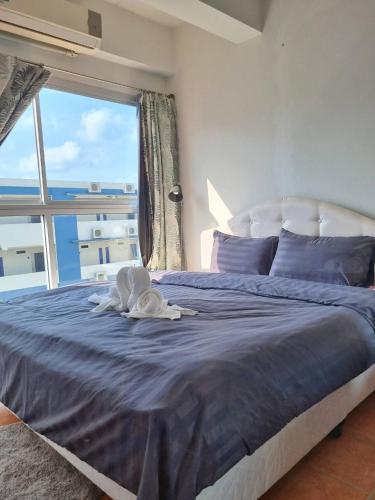 a bedroom with a large bed with a large window at Avatara B condominium B54 in Ban Tha Fat