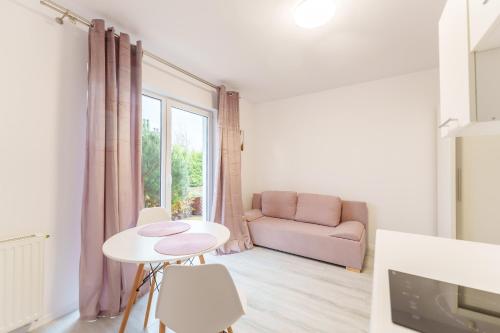 Nadmorski Apartament V by Holiday&Sun في جيبوفو: غرفة معيشة مع أريكة وطاولة