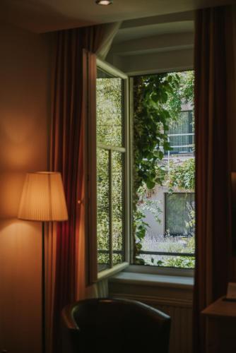 a window in a room with a chair and a lamp at Boutiquehotel Stadthalle in Vienna