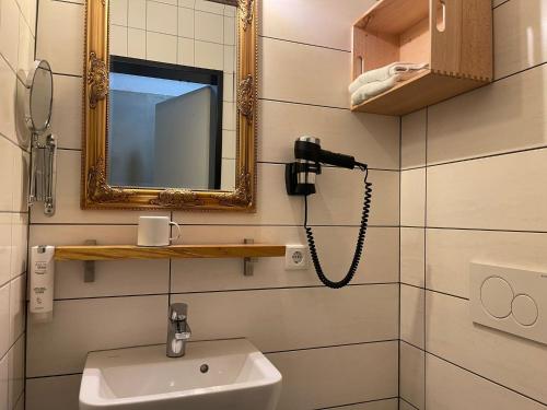 een badkamer met een wastafel en een telefoon aan de muur bij KobyApartment Souterrain in Herford