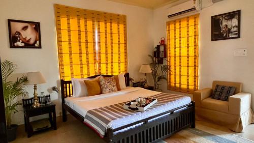 a bedroom with a bed and a chair and yellow curtains at The Sunshine Room, Deluxe room in The Umri Lansdowne in Lansdowne