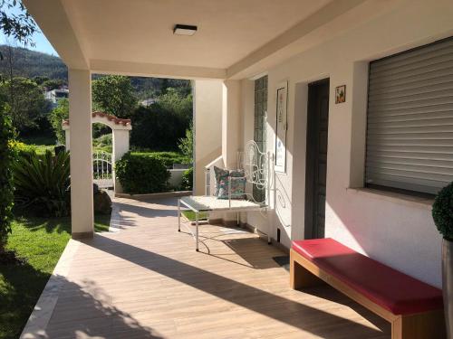 a porch of a house with a bench and a window at Casa da Avó Olinda in Góis