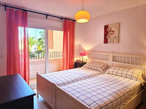 a bedroom with a bed and a large window at Espliego Pool View Apartment in Torre-Pacheco
