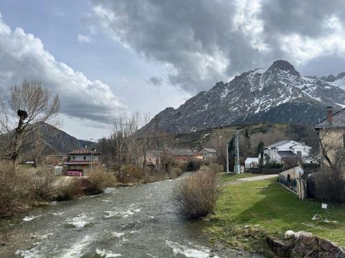 un fiume in un villaggio con una montagna sullo sfondo di Casas Rurales Cuatro Valles a Naredo de Fenar