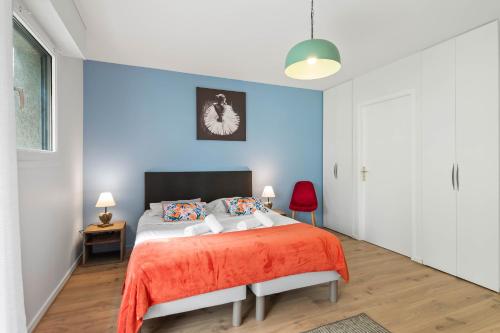 une chambre avec un lit et un mur bleu dans l'établissement Terraces of Bonlieu - cozy apartment, à Annecy