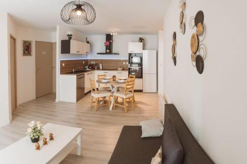 a kitchen and living room with a table and chairs at Le Cocon Manceau in Le Mans