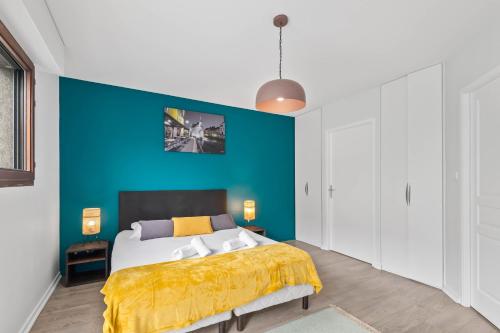 a bedroom with a bed with a blue wall at Terraces of Bonlieu - the nest in Annecy