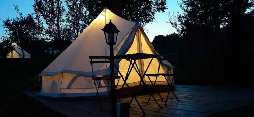 a white tent with a street light in the dark at Glamping Cisnadioara in Cisnadioara