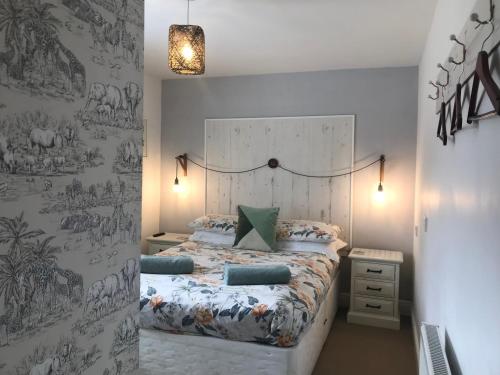 a bedroom with a bed and a wall with drawings on it at Netherdene Country House Bed & Breakfast in Troutbeck