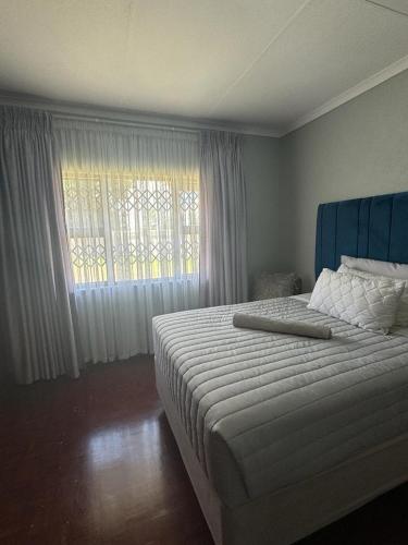 a bedroom with a large bed and a window at Icebolethu Guest House in Standerton