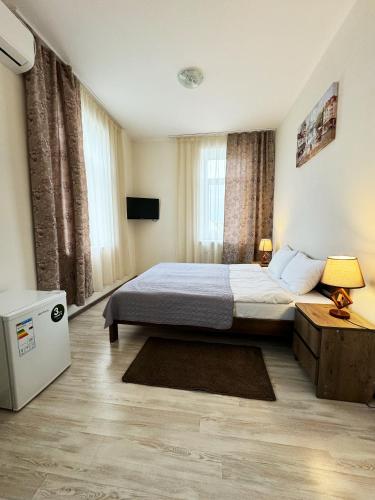 a bedroom with a bed and a table and a television at SIGNEEV'S Villa in Kyiv