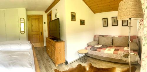 a bedroom with a couch and a television in a room at Villa Edyta Ellmau in Ellmau