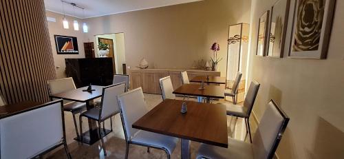 LARANDA rooms في ميلاتسو: مطعم فيه طاولات وكراسي في الغرفة