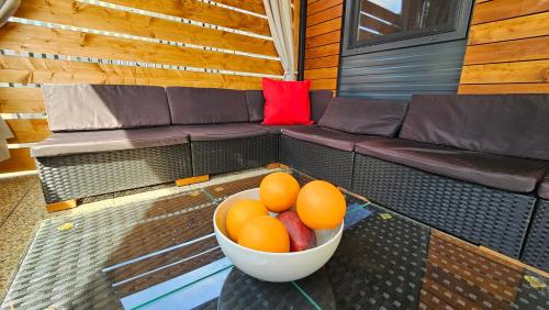 a bowl of oranges and fruit on a bench at CHARTA mobile home Roko in Pirovac