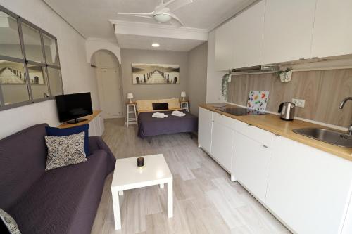 ラ・マタにあるApartment Blanco - Vina Mar IIIの紫色のソファ付きのリビングルーム、キッチンが備わります。
