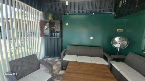 Habitación con 2 sillas, mesa y pared verde en Galaxy Inn, en Khurda