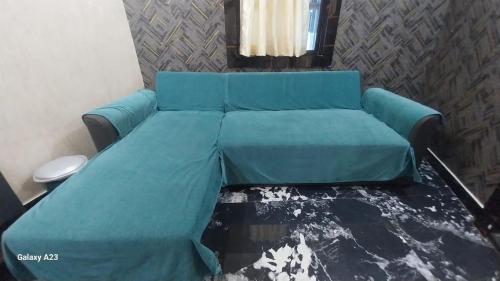 un sofá azul sentado en una sala de estar en Galaxy Inn, en Khurda