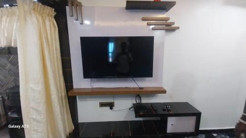 TV de pantalla plana en la pared en Galaxy Inn, en Khurda