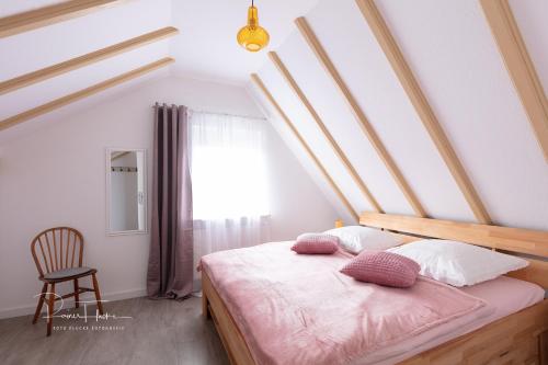 a bedroom with a bed with pink sheets and a chair at Ferienhaus Specht in Schotten