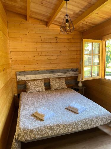 a bedroom with a bed in a log cabin at Ohana Gerês House in Ruivãis