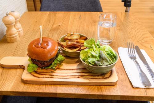 a hamburger and french fries and a salad on a table at ibis Styles Tours Centre in Tours