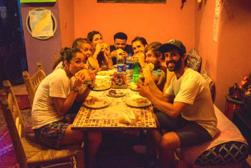 a group of people sitting around a table eating at Hostel Kif-Kif in Marrakesh