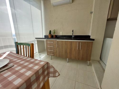 聖保羅的住宿－São Paulo Alto Padrão, PINHEIROS - 110 m2 - SP TOP IMÓVEIS - Piscina aquecida，厨房配有水槽和带桌布的桌子
