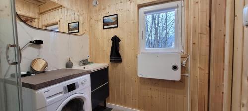 a kitchen with a washing machine in a tiny house at Kolej na sudety in Leszczyniec