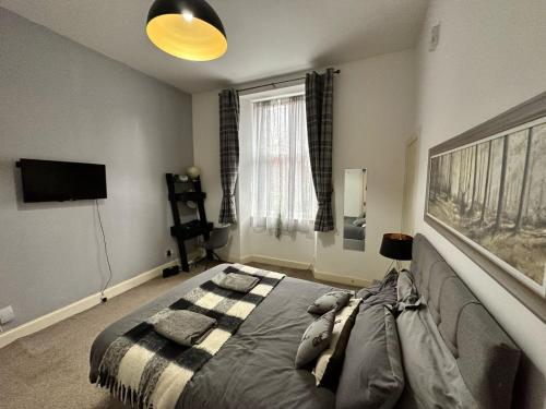 1 dormitorio con 1 cama y TV en City Lights Apartment en Edimburgo